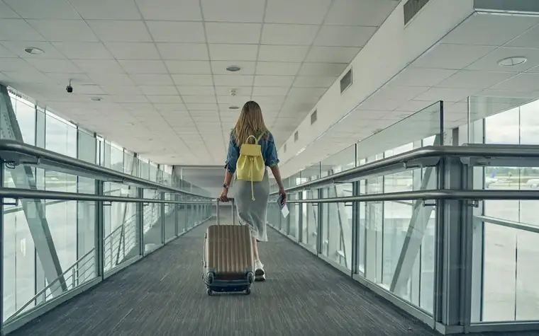 Reisende mit Gepäck in einer Flughafenhalle