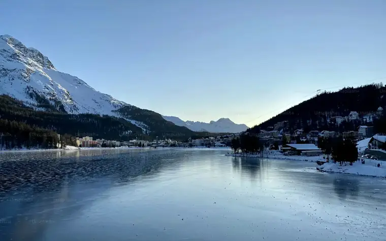 Ruhiger See vor verschneiten Bergen